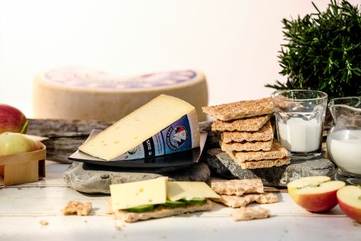 Food-Fotografie mit Käselaib Bio Bodensee Käse, Äpfeln und zwei Gläsern Milch.