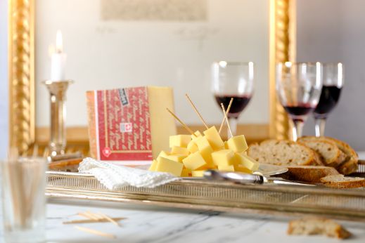 Food-Fotografie mit Käse der Käserei Studer, Brot und Rotweingläsern.