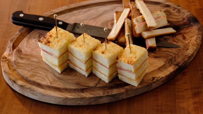 Croque Monsieur angerichtet auf einem Holzbrett