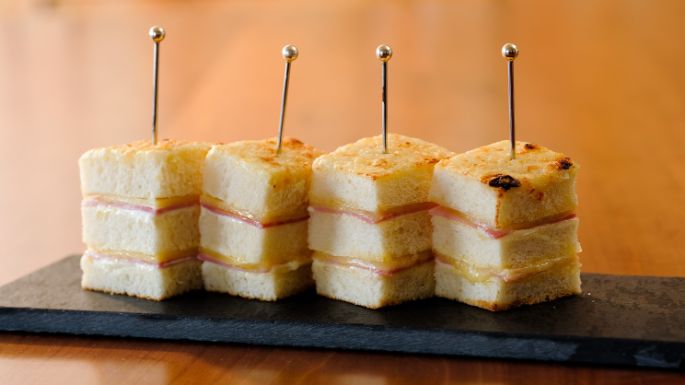 Rezeptidee, Gericht mit Käse Croque Monsieur, angerichtet auf einem Holzbrett